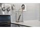 Close-up of stainless steel cooking utensils and oven dials against a gray tiled backsplash at 188 Olympus Way, Kissimmee, FL 34759