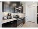 Modern kitchen featuring stainless steel appliances, dark cabinetry, and a stylish tile backsplash at 188 Olympus Way, Kissimmee, FL 34759