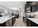 Open-concept kitchen featuring stainless steel appliances, quartz countertops, and a view of the living area at 188 Olympus Way, Kissimmee, FL 34759