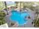 Aerial view of community pool with lounge chairs and tropical landscaping near a lake at 188 Olympus Way, Kissimmee, FL 34759