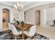 Elegant dining room with chandelier, crown molding, arched entrances, and a view through the home at 2015 Sandy Garden Ln, Winter Garden, FL 34787