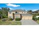 Charming two-story home boasts a three-car garage, stone accents, manicured landscaping, and traditional architectural design at 2015 Sandy Garden Ln, Winter Garden, FL 34787