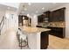 Spacious kitchen with a large island, dark wood cabinets, granite countertops, tile backsplash, and seating for three at 2015 Sandy Garden Ln, Winter Garden, FL 34787