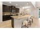Modern kitchen showcasing granite countertops, dark cabinetry, stainless steel appliances, and an expansive island with bar seating at 2015 Sandy Garden Ln, Winter Garden, FL 34787
