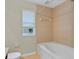 Bathroom featuring a shower and tub combo with neutral tile, a toilet, and a window at 2040 Retreat View Cir, Sanford, FL 32771