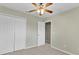 Neutral-toned bedroom with carpet, a ceiling fan, a closet, and a view into another room at 2040 Retreat View Cir, Sanford, FL 32771