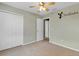 Neutral-toned bedroom with carpet, a ceiling fan, a closet, and a view into another room at 2040 Retreat View Cir, Sanford, FL 32771