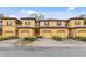 Exterior of townhomes with brown shutters, 1-car garages, and manicured landscaping at 2040 Retreat View Cir, Sanford, FL 32771