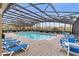Community pool and patio with lounge chairs under a screened enclosure, perfect for relaxation and recreation at 2040 Retreat View Cir, Sanford, FL 32771
