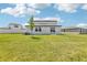 Expansive backyard featuring lush green grass and a modern home design under a bright, cloud-filled sky at 2097 Rosewood Dr, Bartow, FL 33830