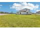 Large backyard with lush green lawn and a modern two-story home with a white fence, creating a serene outdoor space at 2097 Rosewood Dr, Bartow, FL 33830