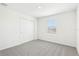 Bright bedroom features plush gray carpet, natural light from the window, and a spacious closet at 2097 Rosewood Dr, Bartow, FL 33830