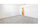 Large bedroom with neutral walls and plush carpeting, features a door leading to other parts of the home at 2097 Rosewood Dr, Bartow, FL 33830