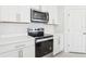 Close up of the stainless steel oven, microwave, and white cabinets in the bright kitchen at 2098 Rosewood Dr, Bartow, FL 33830
