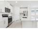 Bright kitchen featuring an island with a sink, stainless appliances and white cabinets at 2098 Rosewood Dr, Bartow, FL 33830
