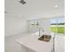 Open-concept kitchen featuring an island, stainless steel sink, and plenty of natural light at 2105 Rosewood Dr, Bartow, FL 33830