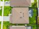 An aerial view shows the roof, small backyard, and screened-in patio of a tan two-story house at 211 Lazio Cir, Debary, FL 32713
