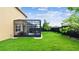 Lush backyard featuring a screened lanai, green grass, and a fenced perimeter for privacy at 211 Lazio Cir, Debary, FL 32713