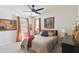 Comfortable bedroom with vibrant orange accents and natural light from two windows at 211 Lazio Cir, Debary, FL 32713