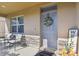 Inviting front porch with seating, decorative wreath, welcome mat, and stone accents creating a warm and welcoming entrance at 211 Lazio Cir, Debary, FL 32713