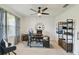 Well-lit office space with a ceiling fan, desk, and decorative shelving unit at 211 Lazio Cir, Debary, FL 32713