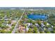 Aerial view showcases neighborhood homes near a lake, connected by a road, offering a serene setting at 250 Cortland Ave, Winter Park, FL 32789