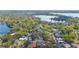 Aerial view of a neighborhood with mature trees, well-maintained homes, and a lake in the background at 250 Cortland Ave, Winter Park, FL 32789