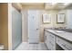 Bathroom with a granite countertop vanity, white cabinets, and a glass-enclosed shower at 250 Cortland Ave, Winter Park, FL 32789