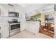 Modern kitchen showcasing white cabinets, stainless steel appliances, and an open view of the billiards room at 250 Cortland Ave, Winter Park, FL 32789