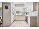 Bright kitchen featuring white cabinetry, tile flooring, stainless steel dishwasher, and a window overlooking greenery at 250 Cortland Ave, Winter Park, FL 32789