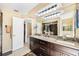 Double sink bathroom vanity with granite countertops and dark cabinets with an oversized mirror and bright lighting at 250 Cortland Ave, Winter Park, FL 32789