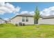 Spacious backyard with a newly planted tree, green grass and an AC unit at 2507 Linda Knoll Ln, Bartow, FL 33830