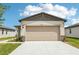 Exterior of home featuring a two-car garage and stone accents on the facade under a blue sky at 2507 Linda Knoll Ln, Bartow, FL 33830