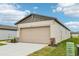 Home exterior showcases a beige garage door, stone accents and manicured lawn under a clear sky at 2507 Linda Knoll Ln, Bartow, FL 33830