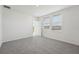 Bright bedroom with carpet, white walls, two windows, and an entry door at 2514 Linda Knoll Ln, Bartow, FL 33830
