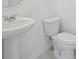 Clean bathroom with a pedestal sink and toilet featuring all-white fixtures and neutral tile at 2518 Linda Knoll Ln, Bartow, FL 33830