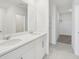 A luxurious bathroom boasts a double vanity and modern fixtures with a view to the walk-in closet at 2518 Linda Knoll Ln, Bartow, FL 33830
