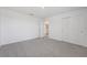 A bright carpeted bedroom featuring a window, closet, and open door at 2518 Linda Knoll Ln, Bartow, FL 33830