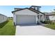 Charming home with a two-car garage, manicured lawn, and a light blue front door at 2518 Linda Knoll Ln, Bartow, FL 33830