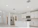 Bright kitchen with stainless steel appliances and an island, complemented by white cabinets and recessed lighting at 2518 Linda Knoll Ln, Bartow, FL 33830