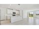 Modern, all-white kitchen with island, stainless steel appliances, and open layout leading to the living area at 2518 Linda Knoll Ln, Bartow, FL 33830