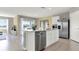 Open kitchen with white cabinets, a large island, and stainless steel appliances overlooking the living area at 2825 Jamaica Way, Haines City, FL 33844