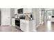 Functional kitchen featuring stainless steel appliances, white cabinetry, and access to other rooms at 2825 Jamaica Way, Haines City, FL 33844