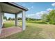 Covered brick patio with gray support beams overlooking a green backyard and a pond at 2948 Wild Olive Dr, St Cloud, FL 34772