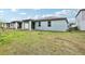 View of the backyard and covered patio featuring newly-seeded grass with other homes nearby at 2948 Wild Olive Dr, St Cloud, FL 34772