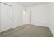 Neutral carpeted bedroom with closet and hallway doors, creating a practical and functional space at 2948 Wild Olive Dr, St Cloud, FL 34772
