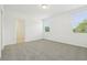 This bedroom is bright with two windows, neutral carpet, and an en suite bathroom at 2948 Wild Olive Dr, St Cloud, FL 34772