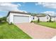 Lovely one-story home with a brick driveway, attached garage, and meticulously manicured lawn at 2948 Wild Olive Dr, St Cloud, FL 34772