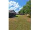 A large backyard featuring an iron fence, a brick wall, and a covered patio at 3125 Timucua Cir, Orlando, FL 32837