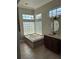 Bright bathroom featuring a soaking tub, glass block window, tiled floors, and a single vanity at 3125 Timucua Cir, Orlando, FL 32837
